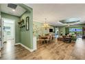 Open living and dining area with hardwood floors and views of outdoor living space with retractable sliding glass doors at 5329 Trails Bend Ct, Sarasota, FL 34238