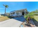 Well-maintained single-story home with a spacious carport and tropical landscaping at 5619 Bayshore Rd # 423, Palmetto, FL 34221