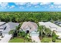 An aerial view of a well-maintained home, showcasing its tile roof, landscaping, and peaceful, wooded surroundings at 7278 Lismore Ct, Lakewood Ranch, FL 34202