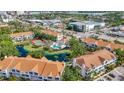 Aerial shot of the condo community showcasing the pool, tennis courts, pond, and surrounding neighborhood at 850 S Tamiami Trl # 730, Sarasota, FL 34236