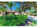 Beautifully landscaped front yard with mature trees and vibrant greenery leading to the home's entrance at 9121 Stone Harbour Loop, Bradenton, FL 34212