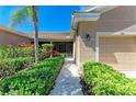Inviting home entrance with lush landscaping, a sidewalk, and a view of the screened-in porch at 9121 Stone Harbour Loop, Bradenton, FL 34212