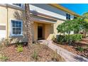 Charming home entrance with a brick walkway, a manicured garden, and a neutral-toned exterior at 9429 Discovery Ter # 102B, Bradenton, FL 34212