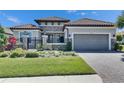 Charming home with a two-car garage, stone accents, and manicured lawn, providing curb appeal at 10510 Giddens Pl, Palmetto, FL 34221