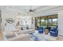 An inviting living room with a ceiling fan and access to an outdoor pool area at 20114 Uffizi Ct, Venice, FL 34293