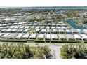 Aerial view of a well-organized community with many homes, landscaping, and a pond at 216 Palm Air Dr, Osprey, FL 34229