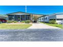 Charming home with a carport, screened porch, and vibrant landscaping on a sunny day at 216 Palm Air Dr, Osprey, FL 34229