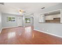 Bright living room with hardwood floors, ceiling fan, and pass through to kitchen at 218 80Th N Ave, St Petersburg, FL 33702