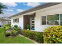 Inviting front entrance with modern door and manicured landscaping enhancing the home's curb appeal at 2242 Sunnyside Ln, Sarasota, FL 34239