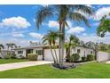 Beautiful home surrounded by palm trees, featuring a well-kept lawn and an attached two-car garage at 2242 Sunnyside Ln, Sarasota, FL 34239