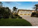 Expansive exterior showcases a well-manicured lawn and a convenient three-car garage at 3322 Bayou Rd, Longboat Key, FL 34228