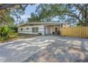 Charming single-story home featuring a beautifully landscaped front yard with mature trees and a brick-paved driveway at 3526 Austin St, Sarasota, FL 34231