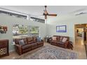 Open living room area with natural light, comfortable leather couches, and views of the landscaped yard at 3526 Austin St, Sarasota, FL 34231