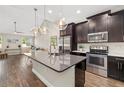 Modern kitchen with stainless steel appliances, dark cabinetry, a gray countertop, and decorative pendant lights at 3644 Pitch Ln, Sarasota, FL 34232