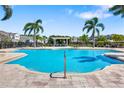Inviting community pool surrounded by palm trees and comfortable lounge areas at 3644 Pitch Ln, Sarasota, FL 34232