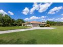 Attractive home featuring an expansive driveway, lush green lawn, and well-maintained landscaping at 4012 Twin Rivers Trl, Parrish, FL 34219