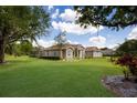 Well-maintained home featuring a lush green lawn, mature trees, and classic architectural details at 4012 Twin Rivers Trl, Parrish, FL 34219