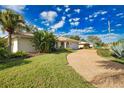 Inviting home featuring lush green lawn, mature landscaping and a charming barrel tile roof at 412 Giovanni Dr, Nokomis, FL 34275