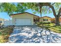Charming single-story home with a two-car garage, well-kept lawn, and mature trees offering shade at 507 Shore Dr, Largo, FL 33771