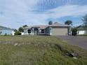 Picture of a one-story home featuring a spacious front yard, well-kept lawn, and a two-car garage at 5578 Thyer St, North Port, FL 34288