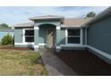Beautiful entranceway to a cozy home, featuring a tidy lawn and charming landscaping at 5578 Thyer St, North Port, FL 34288
