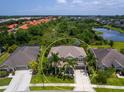 Aerial view of a home with a beautiful backyard pond surrounded by lush greenery at 5742 Hydrangea Cir, Sarasota, FL 34238