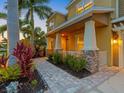 Inviting front porch with stone accents and beautiful landscaping leads to the front door at 5742 Hydrangea Cir, Sarasota, FL 34238