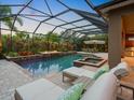 Relaxing screened-in pool and spa area with outdoor seating and a cozy fire pit at 5742 Hydrangea Cir, Sarasota, FL 34238