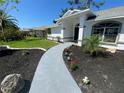 Inviting front entrance with a light gray walkway and beautifully landscaped flower beds at 5810 42Nd E St, Bradenton, FL 34203