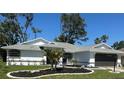 Charming single-story home with a well-manicured lawn and dark gray garage door at 5810 42Nd E St, Bradenton, FL 34203