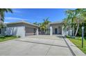 The exterior of the house shows a garage and a paved driveway with tropical landscaping around the house at 5856 Meriwether Pl, Sarasota, FL 34232
