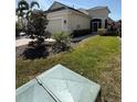 Well-maintained home featuring verdant landscaping, an attached garage, and a welcoming entrance at 7608 Registrar Way, Sarasota, FL 34243