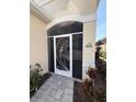 Charming front door with an artistic metal screen, surrounded by lush plants at 7608 Registrar Way, Sarasota, FL 34243