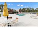 Community pool area featuring lounge chairs, a yellow umbrella, and well-maintained surroundings at 9100 Dr Martin Luther King Jr N St # 205, St Petersburg, FL 33702