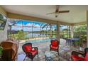 Inviting screened lanai features comfortable seating, a ceiling fan, and a beautiful view of the pool and lake at 1017 Siberian Glen, Bradenton, FL 34212