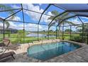 A screened in private pool overlooking a pond with beautiful views and a brick deck at 1017 Siberian Glen, Bradenton, FL 34212