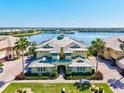 Waterfront condo building featuring a unique roofline with palm trees, landscaping, and a waterfront view at 1123 Riverscape St # D, Bradenton, FL 34208