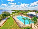 Aerial view of the community pool with lush landscaping, lounge chairs, and an adjacent walking path at 1123 Riverscape St # D, Bradenton, FL 34208