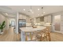 Open kitchen with a large marble island, stainless steel appliances, and pendant lighting at 11606 Apple Tree Cir, Bradenton, FL 34211
