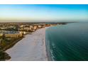 Stunning aerial view showcasing the coastline, featuring a beautiful white sand beach meeting clear turquoise water, and city skyline at 1163 Coquille St # 207, Sarasota, FL 34242