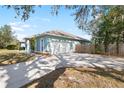 Side view of a light blue home showcasing the garage, a fenced yard, and a spacious driveway at 12103 Shadow Run Blvd, Riverview, FL 33569