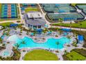 Aerial view of a luxurious community pool with palm trees, lounge chairs, and a splash pad at 12557 Galapagos Ct, Venice, FL 34293