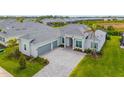 Beautiful single-story home with a gray tile roof, a three-car garage, and a lush green lawn at 12557 Galapagos Ct, Venice, FL 34293