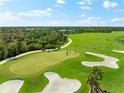 Scenic golf course view with lush green fairways, sand traps, and players enjoying a round in a landscaped community at 12557 Galapagos Ct, Venice, FL 34293