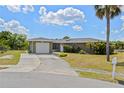 Charming single-story home with a well-maintained lawn, paved driveway, and attached garage, creating curb appeal at 1665 Harmony Dr, Port Charlotte, FL 33952