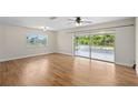 Spacious living room with wood floors, ceiling fans, and sliding glass doors leading to an enclosed porch with a view at 1665 Harmony Dr, Port Charlotte, FL 33952