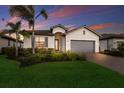 Beautiful home with a two-car garage, a tile roof, nice landscaping, and attractive exterior paint at 20892 Cattail Blvd, Venice, FL 34292