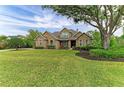 Charming stone home boasts a lush lawn and mature shade tree at 22235 Panther Loop, Bradenton, FL 34202