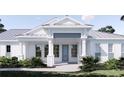 Inviting front entry showcases a blue door, white columns, and a charming brick walkway surrounded by lush greenery at 2508 Belvoir Blvd, Sarasota, FL 34237