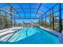 Sparkling screened-in pool with a waterfall feature and a picturesque view of the waterfront at 435 La Sila Ct, Punta Gorda, FL 33950